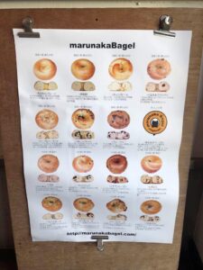 たくさんの種類のベーグルのメニューが壁に貼られている写真